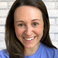 Headshot of Abby Blechman. Abby has long, brown hair, is smiling and is wearing a purple t-shirt with Sound Start embroidered in white.
